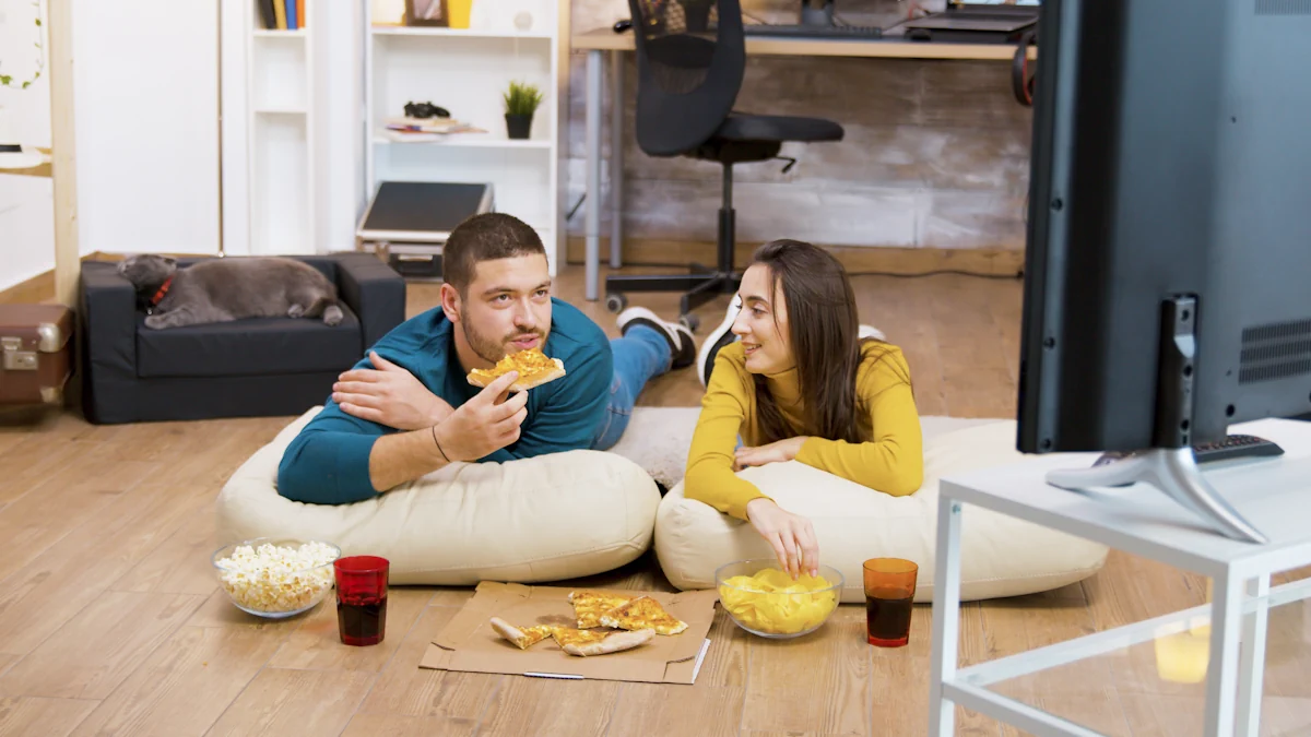 Un couple qui mange une pizza devant la télé