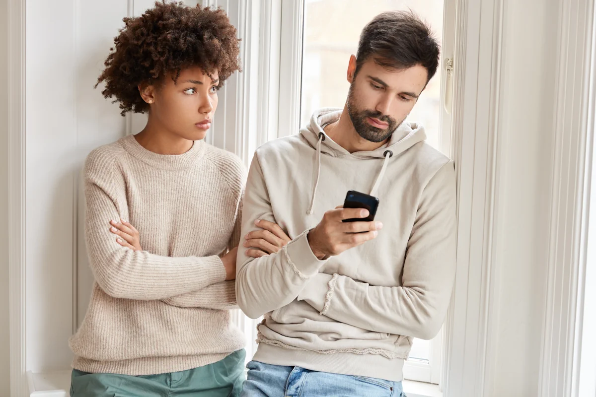 Une femme qui regarde son homme sur son téléphone